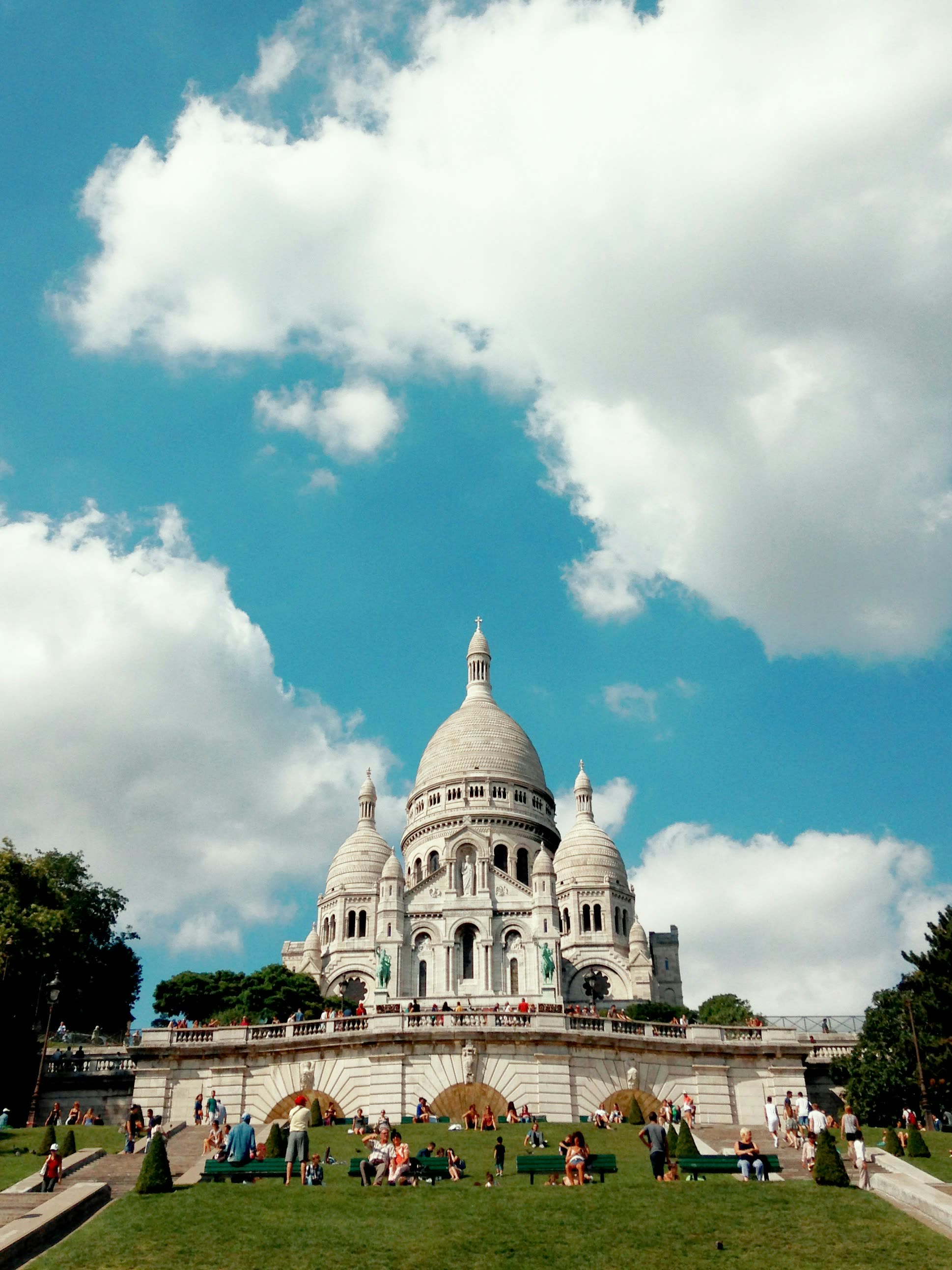 Sacré-Cœur seen from the lawns below, people sitting on the grass in front of it